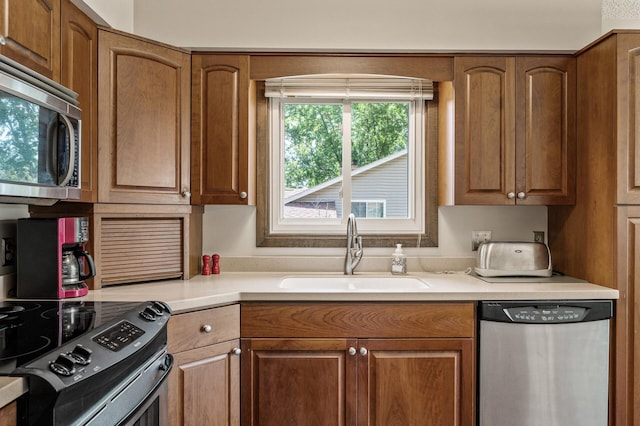 4133 88th Ave NE, Blaine, MN 55014 - kitchen featuring appliances with stainless steel finishes, light countertops, and brown cabinets