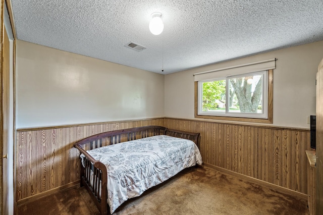 4133 88th Ave NE, Blaine, MN 55014 - bedroom featuring wainscoting, wood walls, a textured ceiling, and carpet flooring