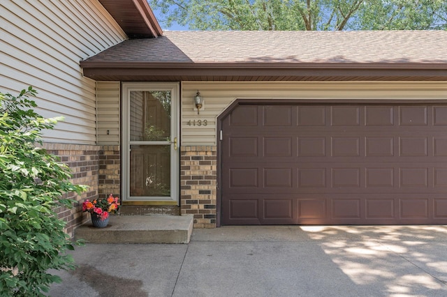 4133 88th Ave NE, Blaine, MN 55014 - view of exterior entry featuring roof with shingles, concrete driveway, and a garage