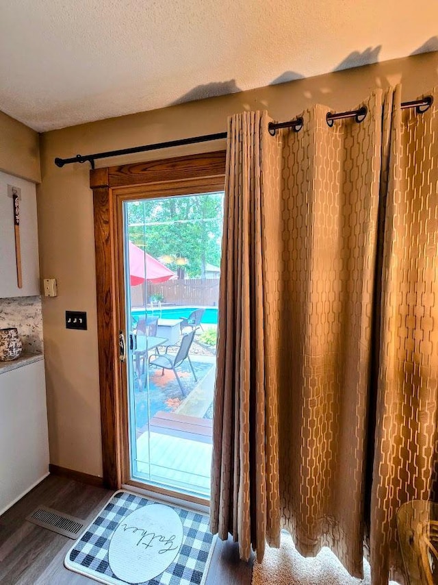 902 6th Ave SE, Pipestone, MN 56164 - doorway to outside with wood finished floors and a textured ceiling