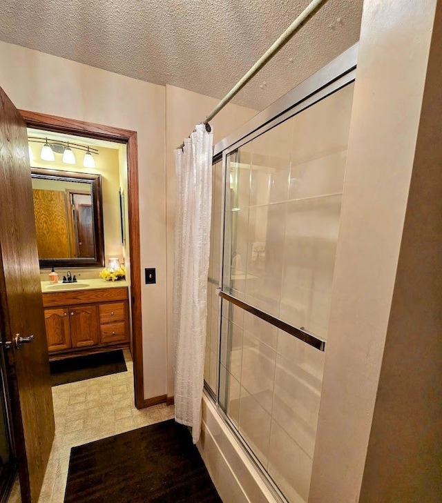 902 6th Ave SE, Pipestone, MN 56164 - bathroom featuring bath / shower combo with glass door, vanity, and a textured ceiling