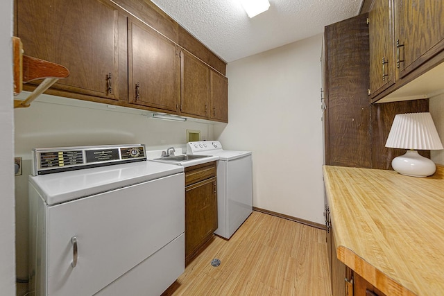 9700 Portland Ave S Unit 237, Bloomington, MN 55420 - washroom featuring cabinet space, light wood-style flooring, washing machine and dryer, and a textured ceiling