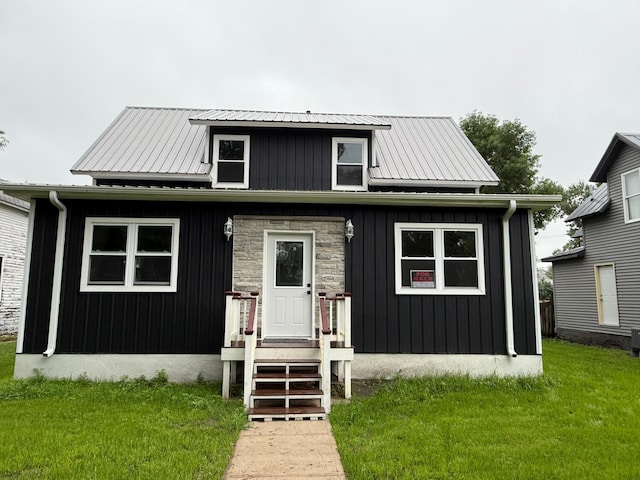409 4th St W, Canby, MN 56220 - bungalow-style house with a front yard, a metal roof, and board and batten siding