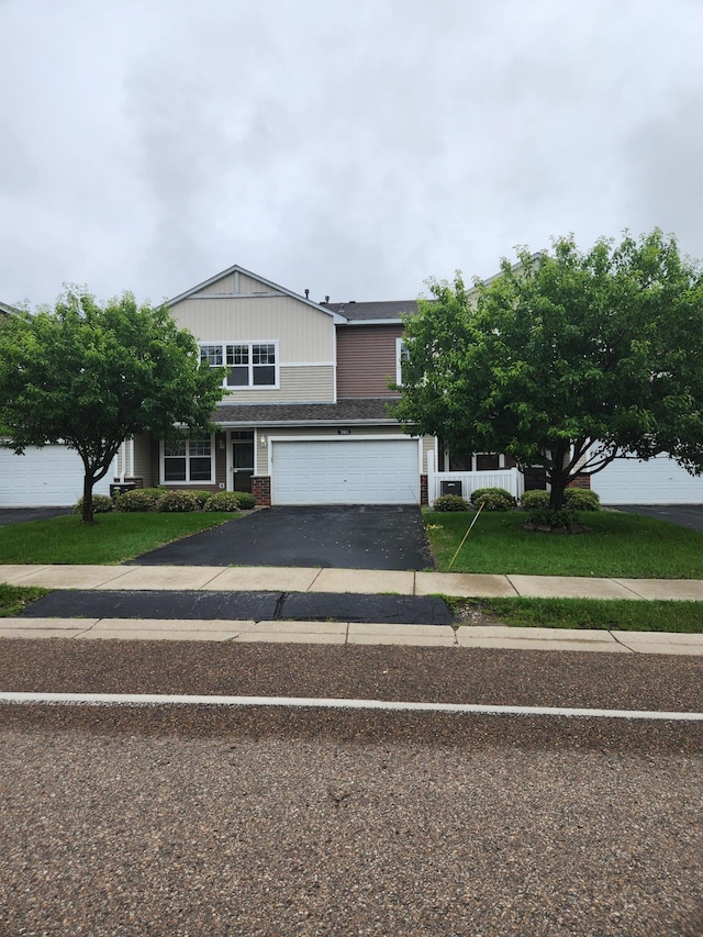 703 10th St S, Buffalo, MN 55313 - view of front of property with driveway, a garage, brick siding, and a front yard