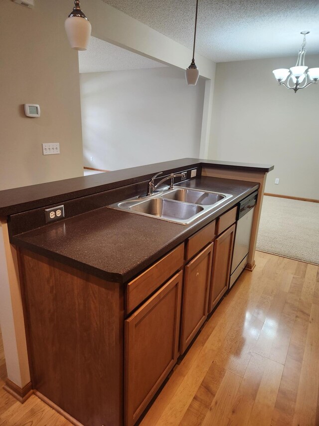 703 10th St S, Buffalo, MN 55313 - kitchen with dishwasher, dark countertops, light wood-style floors, hanging light fixtures, and a textured ceiling