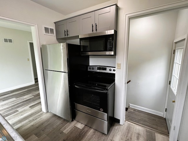 217 6th St SE, Barnesville, MN 56514 - kitchen with stainless steel appliances, light wood-style flooring, and gray cabinetry