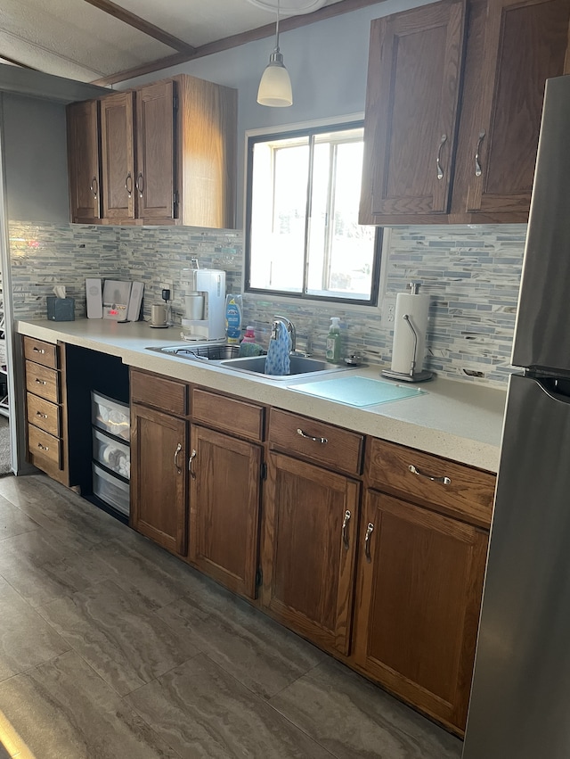 1323 Pine Tree Dr, Maplewood, MN 55119 - kitchen featuring decorative backsplash, light countertops, hanging light fixtures, and freestanding refrigerator