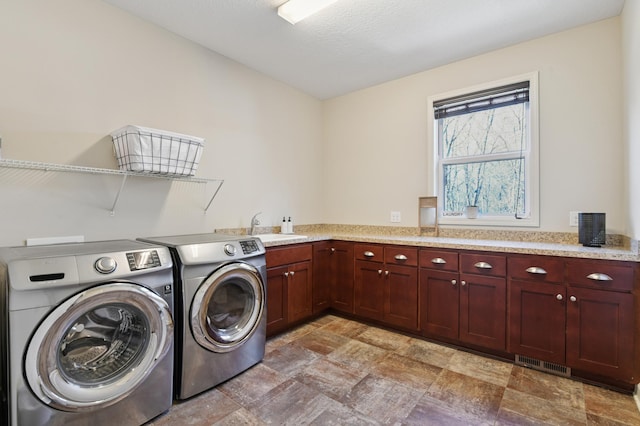 3608 Strawberry Ln, Chanhassen, MN 55331 - laundry area featuring independent washer and dryer, stone finish floors, and cabinet space