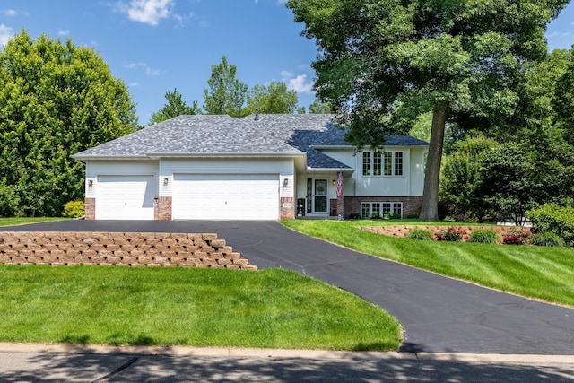 22615 Janero Ave N, Forest Lake, MN 55025 - split level home with an attached garage, driveway, brick siding, a front yard, and roof with shingles