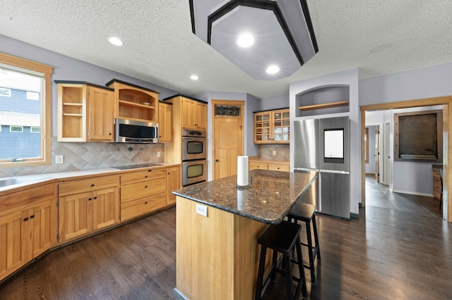 4802 102nd Trl N, Brooklyn Park, MN 55443 - kitchen with open shelves, appliances with stainless steel finishes, a textured ceiling, a center island, and a breakfast bar area