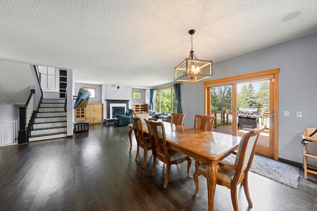 4802 102nd Trl N, Brooklyn Park, MN 55443 - dining area with stairway, a textured ceiling, a fireplace, wood finished floors, and a chandelier