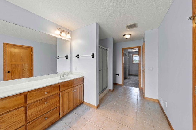 4802 102nd Trl N, Brooklyn Park, MN 55443 - bathroom with vanity, a stall shower, a textured ceiling, and tile patterned flooring