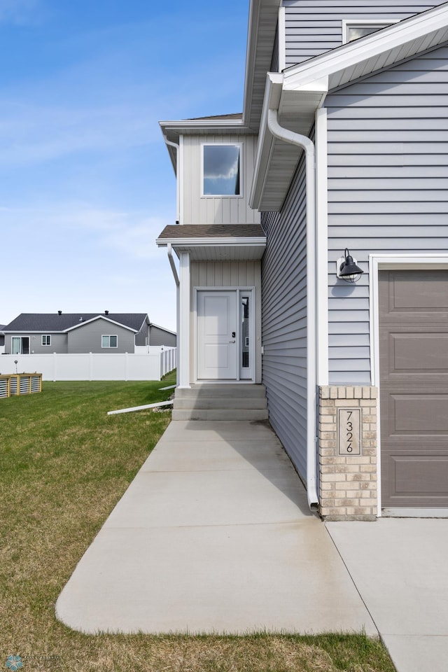 7326 28th St S, Fargo, ND 58104 - property entrance featuring board and batten siding, an attached garage, and stone siding