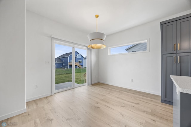 7326 28th St S, Fargo, ND 58104 - unfurnished dining area featuring light wood-type flooring and baseboards