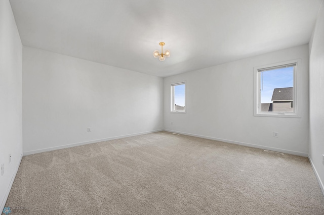 7326 28th St S, Fargo, ND 58104 - spare room featuring a chandelier and light colored carpet