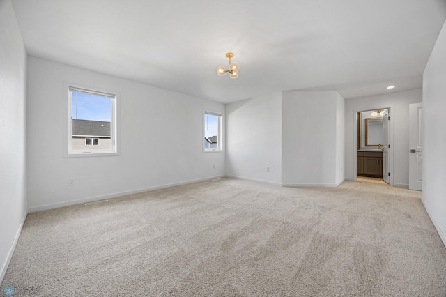 7326 28th St S, Fargo, ND 58104 - spare room featuring a chandelier, plenty of natural light, light colored carpet, and recessed lighting