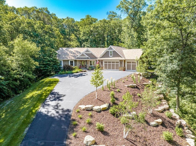 483 Meadow Ridge Ln, Troy Twp, WI 54016 - view of front of house featuring an attached garage, asphalt driveway, a forest view, and stone siding