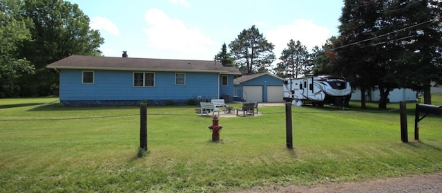 22379 519th Ln, Workman Twp, MN 55760 - rear view of house featuring a detached garage, an outdoor structure, and a lawn