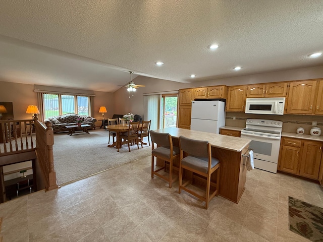 1508 Terrance Cir NE, New Prague, MN 56071 - kitchen with white appliances, healthy amount of natural light, a textured ceiling, light countertops, and a kitchen island