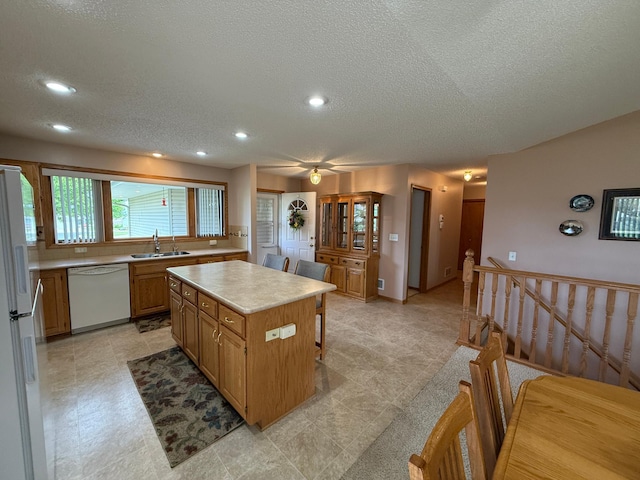 1508 Terrance Cir NE, New Prague, MN 56071 - kitchen with white appliances, light countertops, a kitchen island, a textured ceiling, and recessed lighting