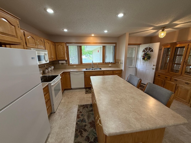1508 Terrance Cir NE, New Prague, MN 56071 - kitchen featuring white appliances, a kitchen island, a textured ceiling, light countertops, and recessed lighting
