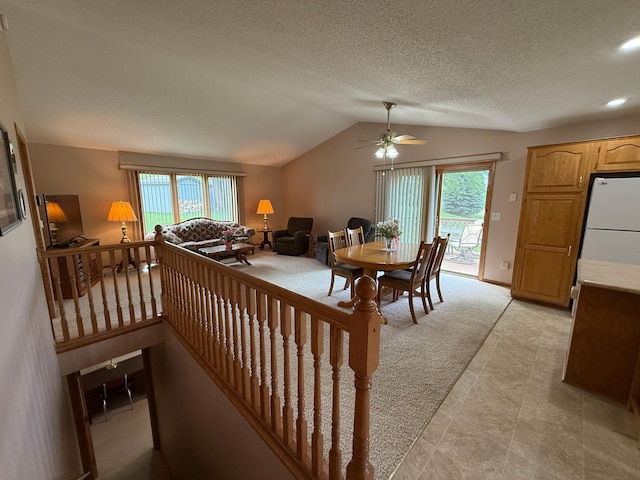 1508 Terrance Cir NE, New Prague, MN 56071 - dining area featuring lofted ceiling, a ceiling fan, light carpet, healthy amount of natural light, and a textured ceiling