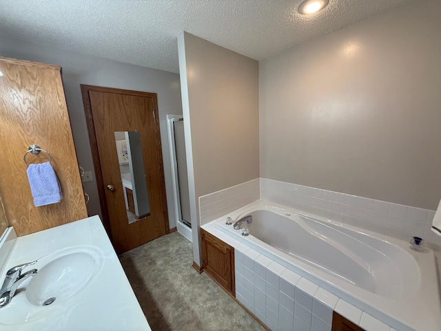 1508 Terrance Cir NE, New Prague, MN 56071 - bathroom featuring a garden tub, a textured ceiling, a shower stall, and vanity