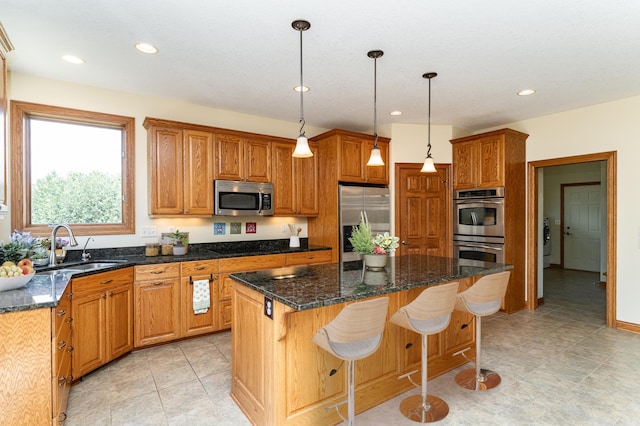 3262 Jade Ct NE, Rochester, MN 55906 - kitchen with appliances with stainless steel finishes, recessed lighting, a kitchen island, a kitchen breakfast bar, and washer / dryer