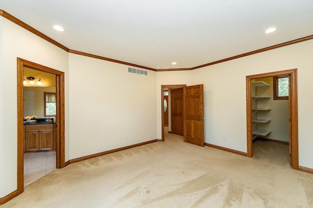 3262 Jade Ct NE, Rochester, MN 55906 - unfurnished bedroom featuring light carpet, ornamental molding, a walk in closet, recessed lighting, and connected bathroom
