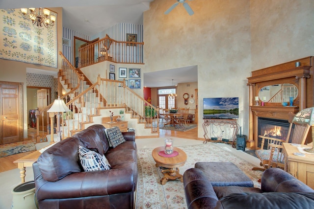 19319 380th St, Erhards Grove Twp, MN 56534 - living room featuring a towering ceiling, wood finished floors, a chandelier, stairs, and a glass covered fireplace