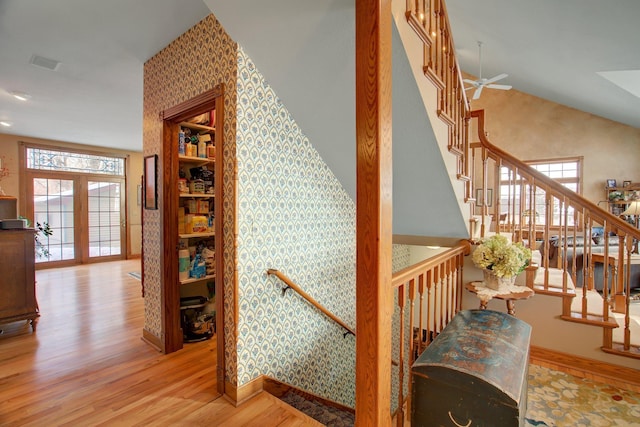 19319 380th St, Erhards Grove Twp, MN 56534 - stairs with wood finished floors, healthy amount of natural light, wallpapered walls, a ceiling fan, and high vaulted ceiling