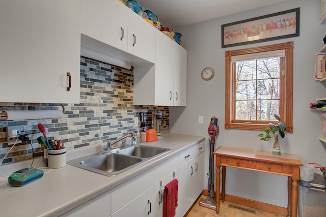 19319 380th St, Erhards Grove Twp, MN 56534 - kitchen featuring backsplash, light countertops, and white cabinetry