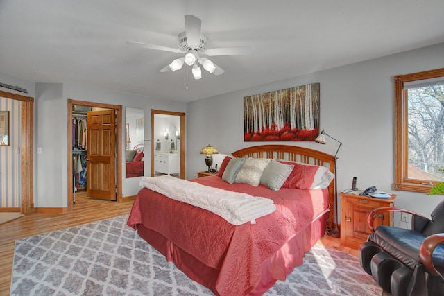 19319 380th St, Erhards Grove Twp, MN 56534 - bedroom featuring wood finished floors, connected bathroom, ceiling fan, and a walk in closet