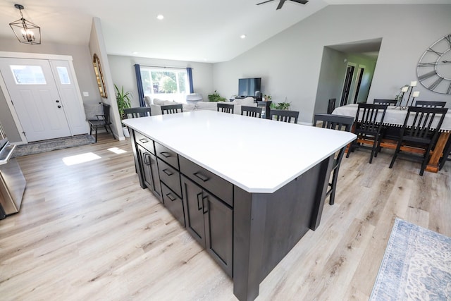 2060 Rosewood Ln SE, Alexandria, MN 56308 - kitchen with a kitchen breakfast bar, light wood finished floors, vaulted ceiling, open floor plan, and light countertops