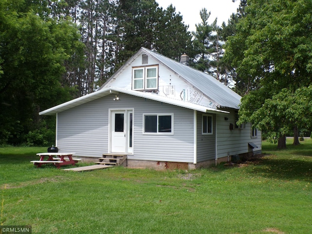 45248 State Highway 48, Clover Twp, MN 55037 - rear view of house with entry steps, a lawn, a chimney, and a metal roof