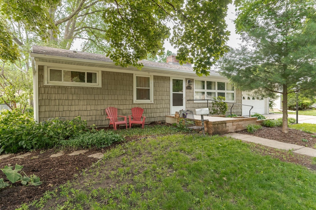 914 11 1/4 St SW, Rochester, MN 55902 - ranch-style home featuring a chimney, an attached garage, a shingled roof, driveway, and a front yard