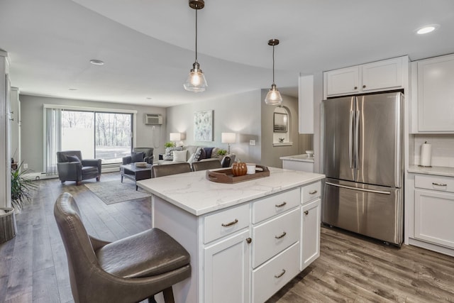10501 Cedar Lake Rd Unit 217, Minnetonka, MN 55305 - kitchen with freestanding refrigerator, wood finished floors, a center island, white cabinetry, and recessed lighting