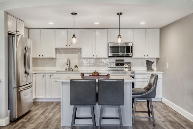 10501 Cedar Lake Rd Unit 217, Minnetonka, MN 55305 - kitchen featuring stainless steel appliances, a breakfast bar area, white cabinetry, light countertops, and backsplash