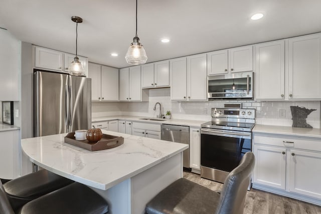 10501 Cedar Lake Rd Unit 217, Minnetonka, MN 55305 - kitchen with stainless steel appliances, light wood-style flooring, white cabinetry, a breakfast bar area, and recessed lighting