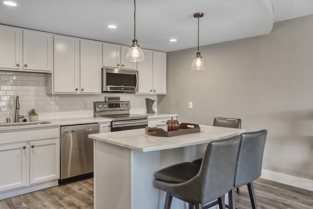 10501 Cedar Lake Rd Unit 217, Minnetonka, MN 55305 - kitchen featuring stainless steel appliances, white cabinetry, light wood-type flooring, a breakfast bar, and recessed lighting