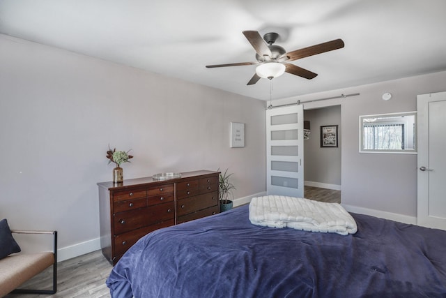 10501 Cedar Lake Rd Unit 217, Minnetonka, MN 55305 - bedroom with a barn door, wood finished floors, and ceiling fan