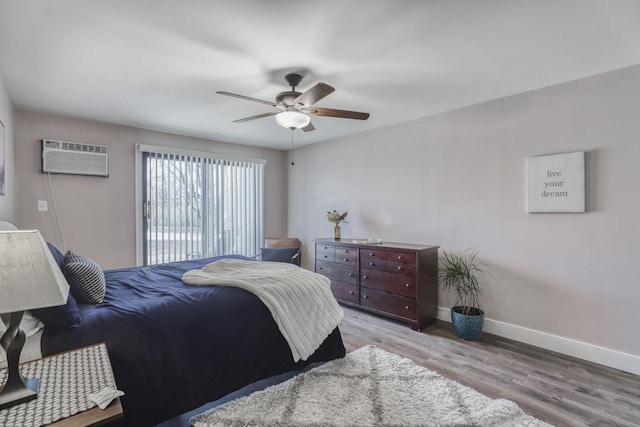 10501 Cedar Lake Rd Unit 217, Minnetonka, MN 55305 - bedroom with wood finished floors, a wall unit AC, and a ceiling fan