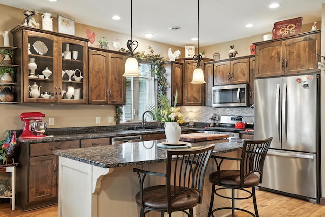 129 Highland Cir, Dassel, MN 55325 - kitchen featuring appliances with stainless steel finishes, light wood finished floors, a center island, a breakfast bar, and recessed lighting