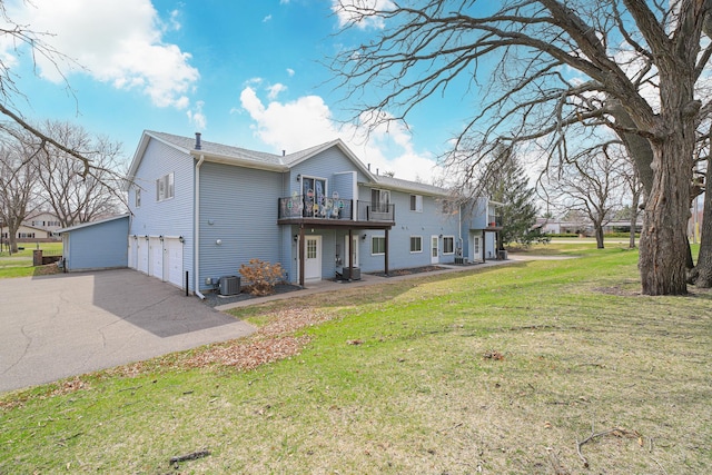83 96th Ln NE, Blaine, MN 55434 - rear view of property with a lawn, asphalt driveway, an attached garage, and a wooden deck