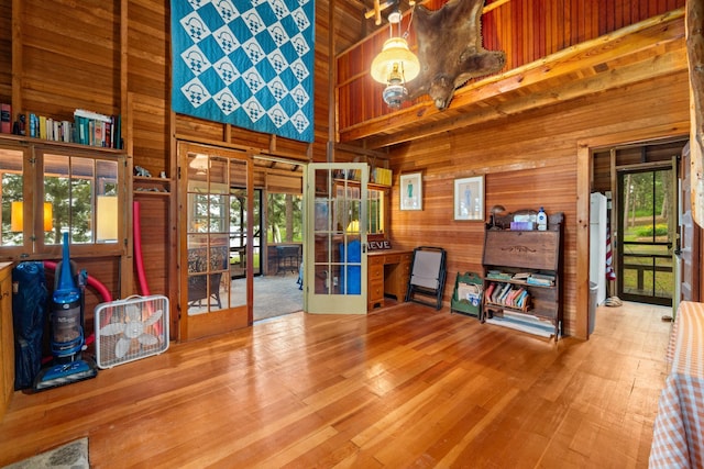 14354 Chippewa Loop, Park Rapids, MN 56470 - miscellaneous room with a towering ceiling, french doors, wood walls, and wood finished floors