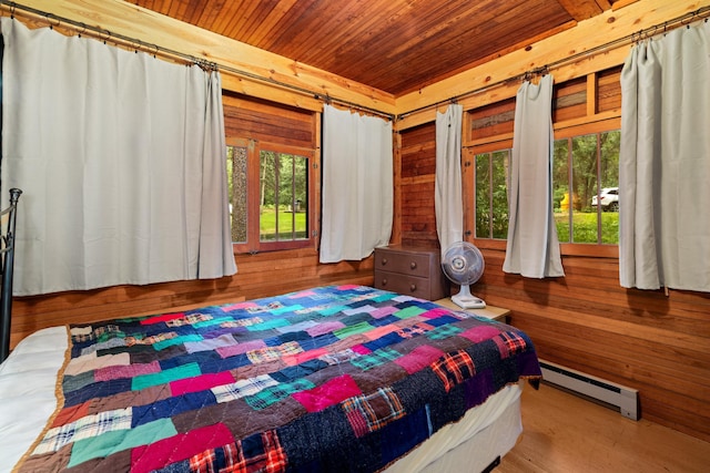 14354 Chippewa Loop, Park Rapids, MN 56470 - bedroom with a baseboard heating unit, wood ceiling, wood walls, multiple windows, and wood finished floors