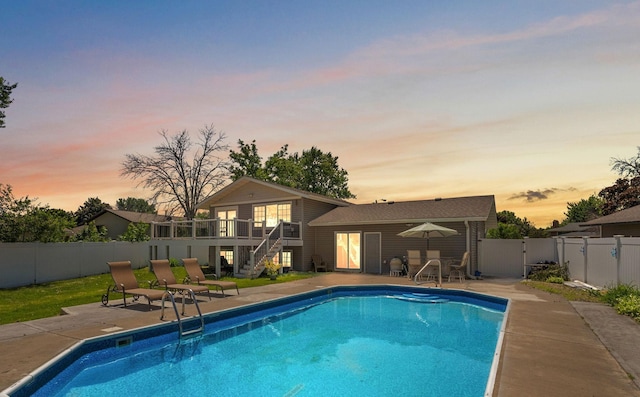 8473 Kentucky Ct N, Brooklyn Park, MN 55445 - pool at dusk with stairway, a fenced backyard, a patio, and a deck