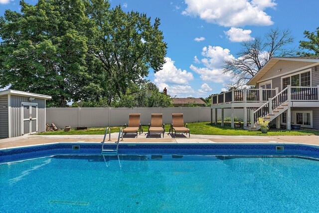8473 Kentucky Ct N, Brooklyn Park, MN 55445 - view of pool with a wooden deck, stairway, a fenced backyard, and a shed