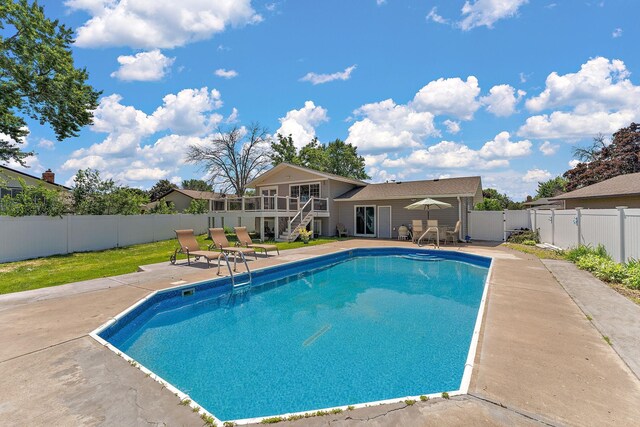 8473 Kentucky Ct N, Brooklyn Park, MN 55445 - view of swimming pool with a patio, a fenced backyard, stairway, and a wooden deck
