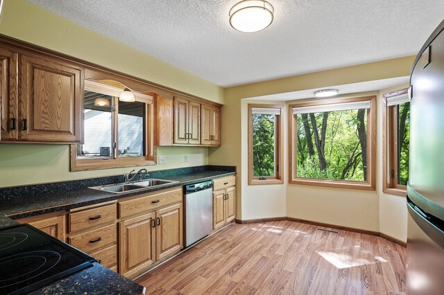 13838 Glendale Trl, Savage, MN 55378 - kitchen featuring dishwasher, plenty of natural light, light wood finished floors, a textured ceiling, and dark countertops